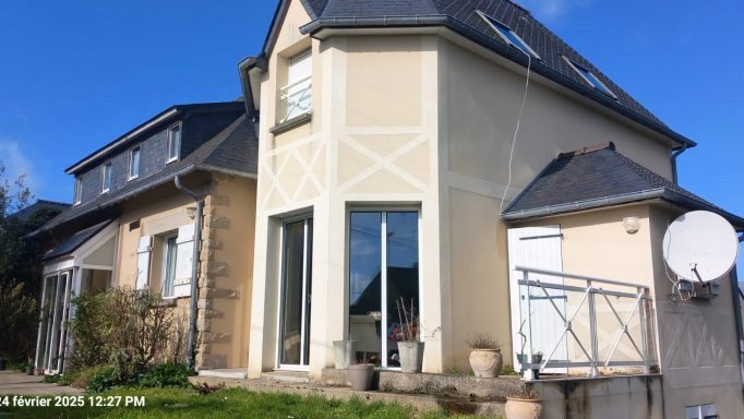 Maison individuelle à deux étages avec balustrade et satellite, sous un ciel bleu.